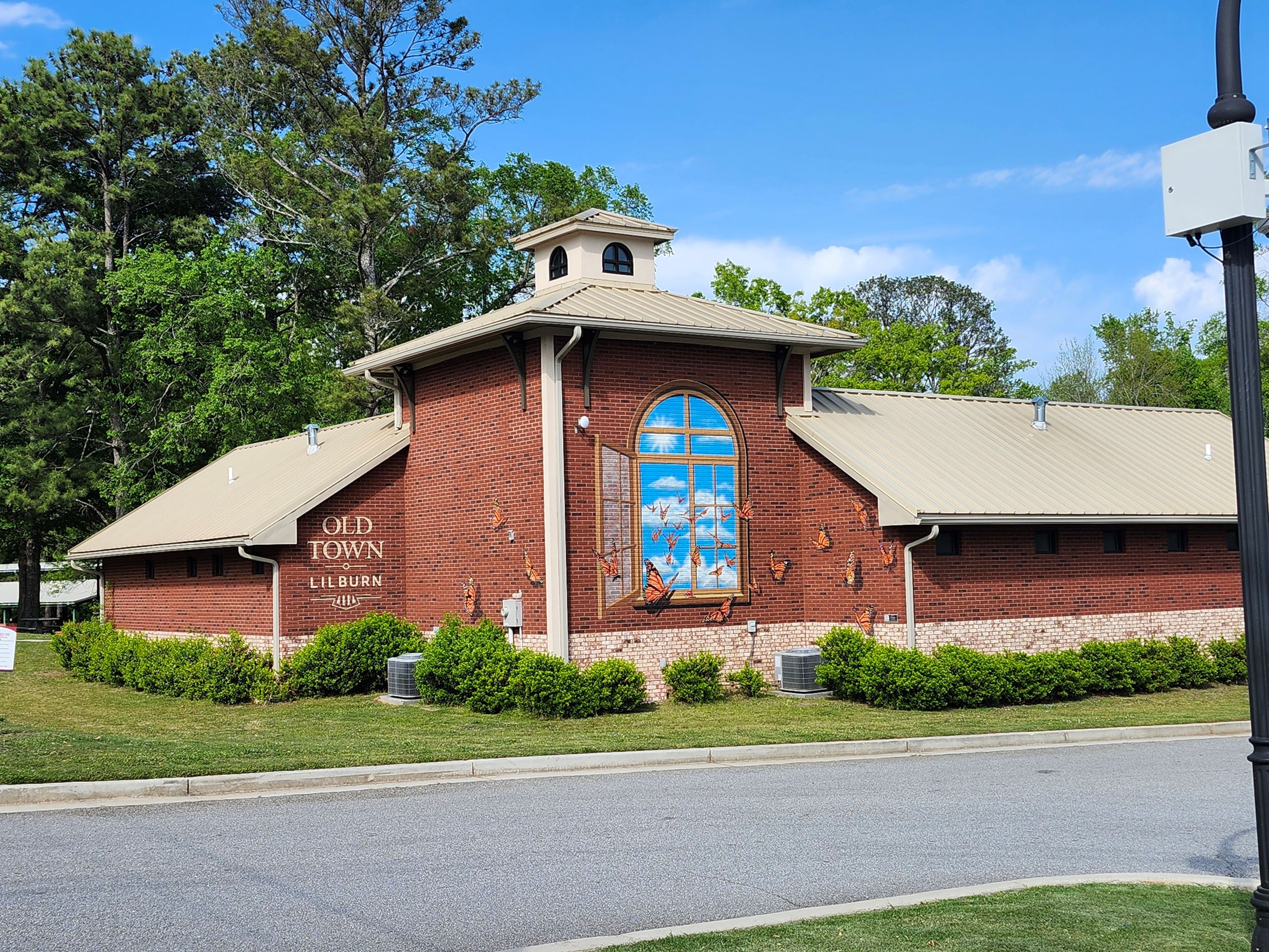 painted mural on a brick building of butterflies flying out of a window