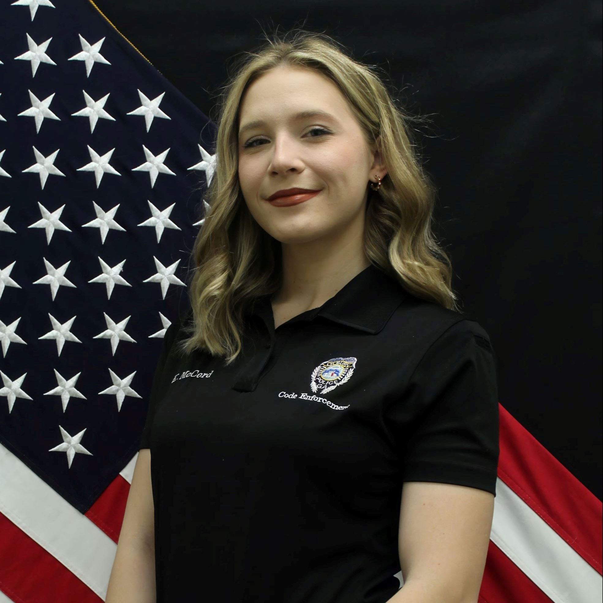 Headshot of Kiersten McCord female with long blond hair wearing black polo and khakis
