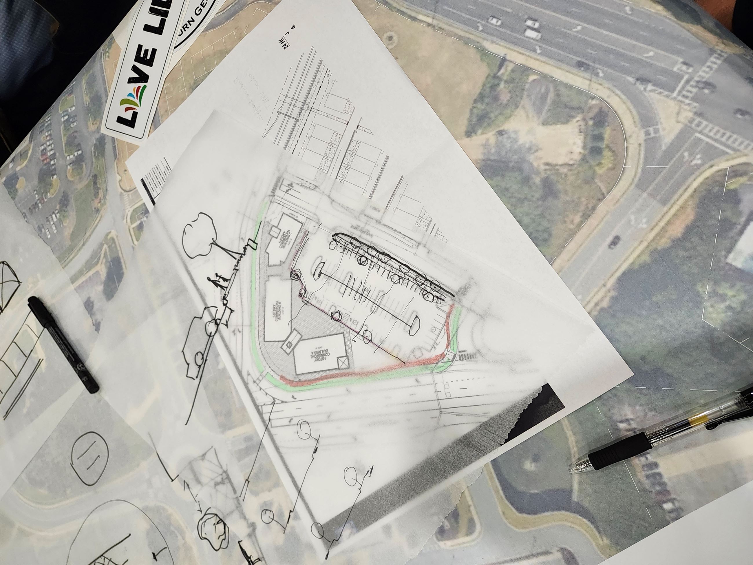 This is a photo of an aerial map image with trace paper and a concept for a retail center.